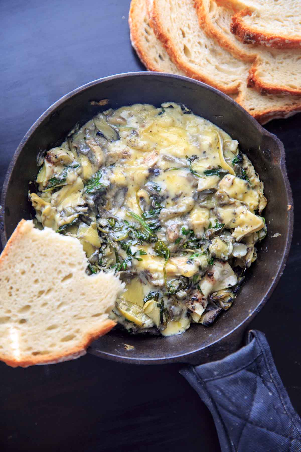 Arugula (or spinach) and artichoke brie dip, made in a cast iron skillet. A delicious and unique appetizer!