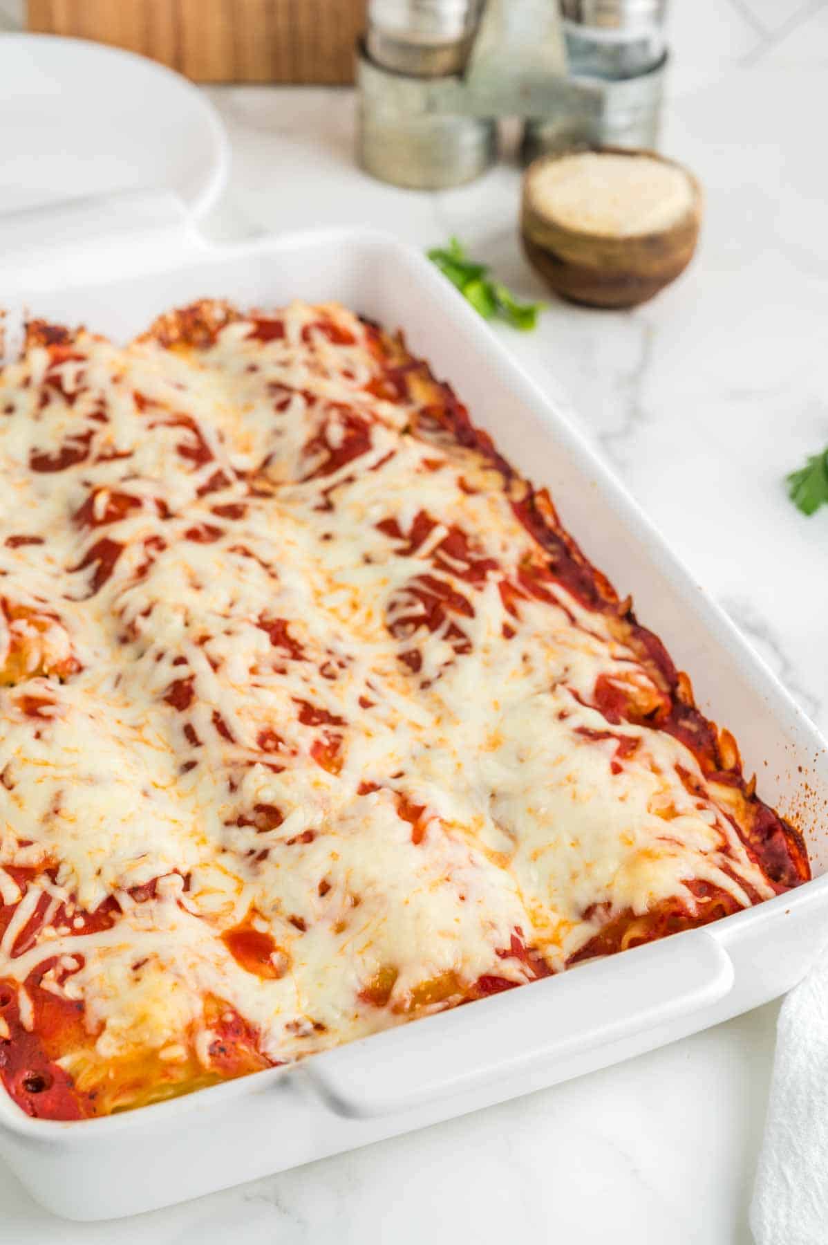 baked lasagna roll ups in a white casserole dish