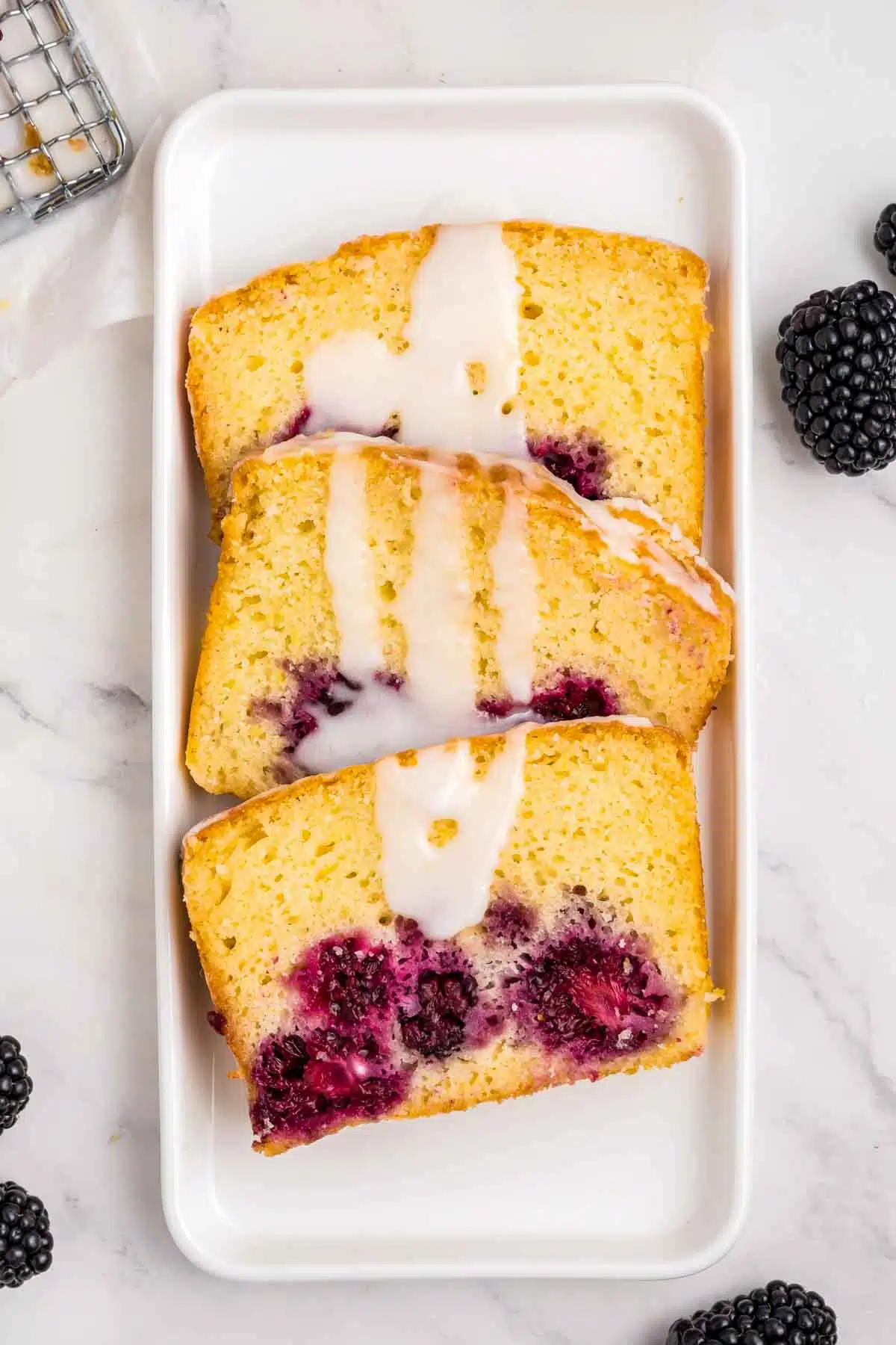 3 pieces of lemon blackberry bread with glaze drizzled over it