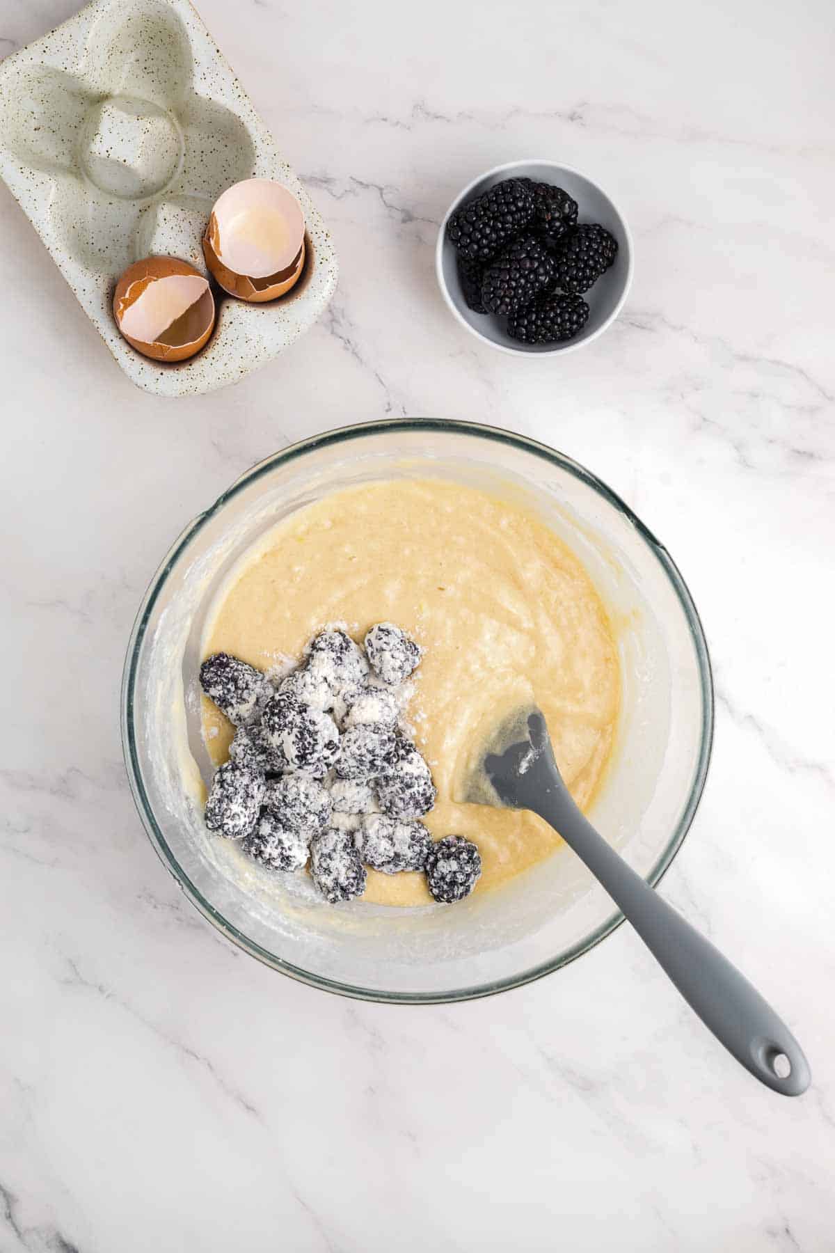 batter for blackberry lemon bread in bowl with fresh blackberries covered in flour