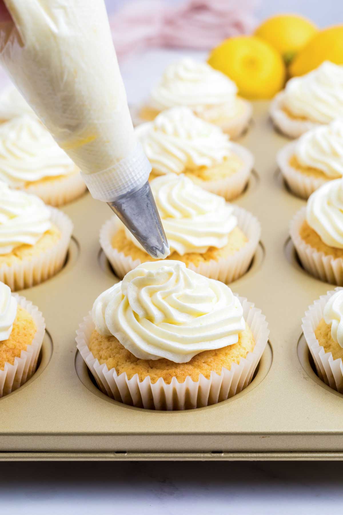 putting frosting on the lemon cupcake