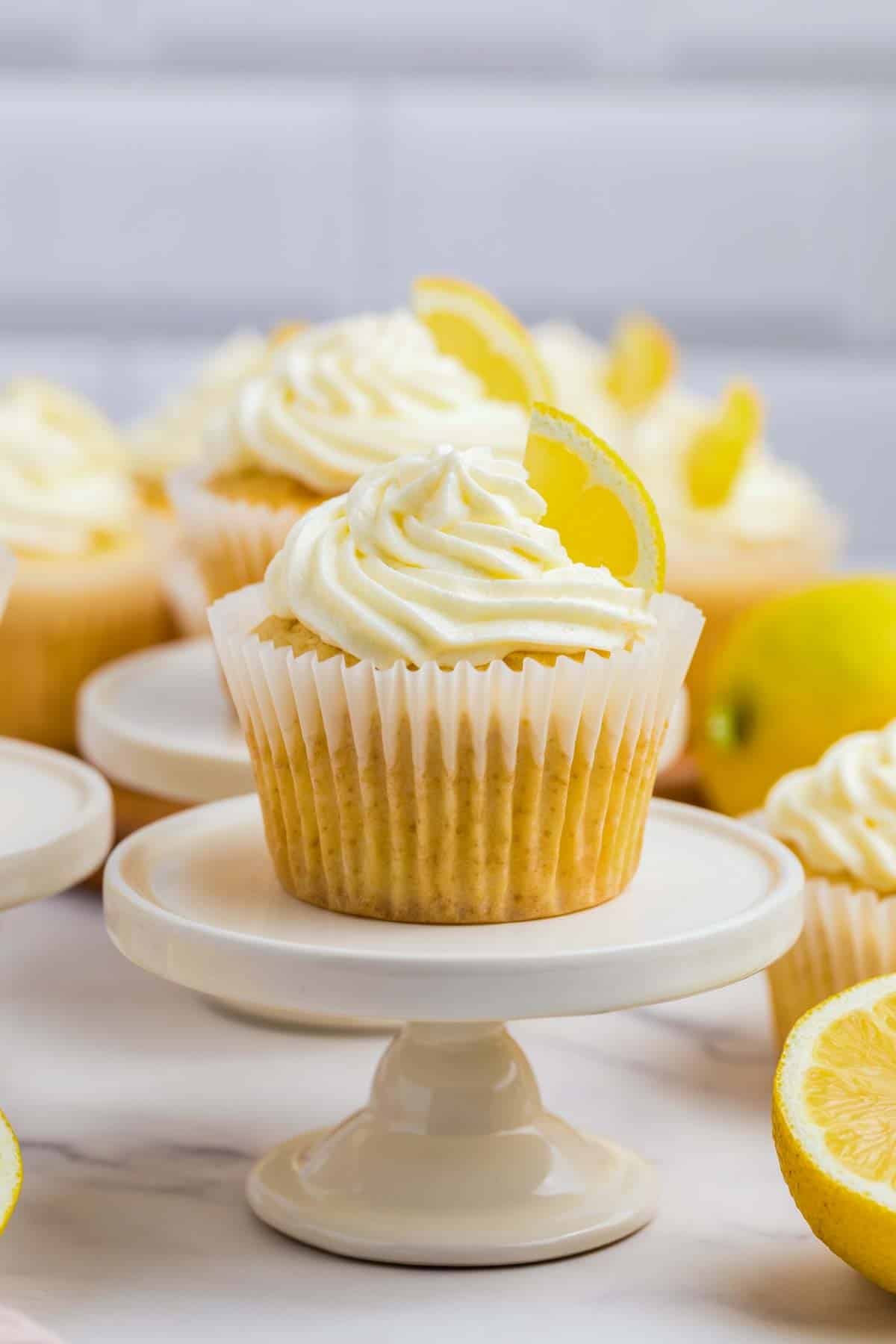 lemon cupcake with lemon buttercream frosting on a white mini cupcake stand