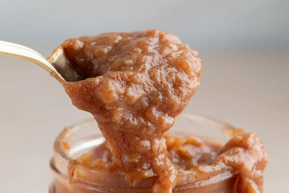 spoonful of homemade banana jam coming out of jar