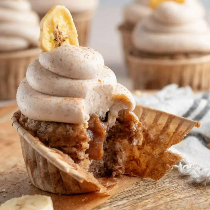 square photo of banana bread cupcake with cupcake liner half taken off to show banana jam filling