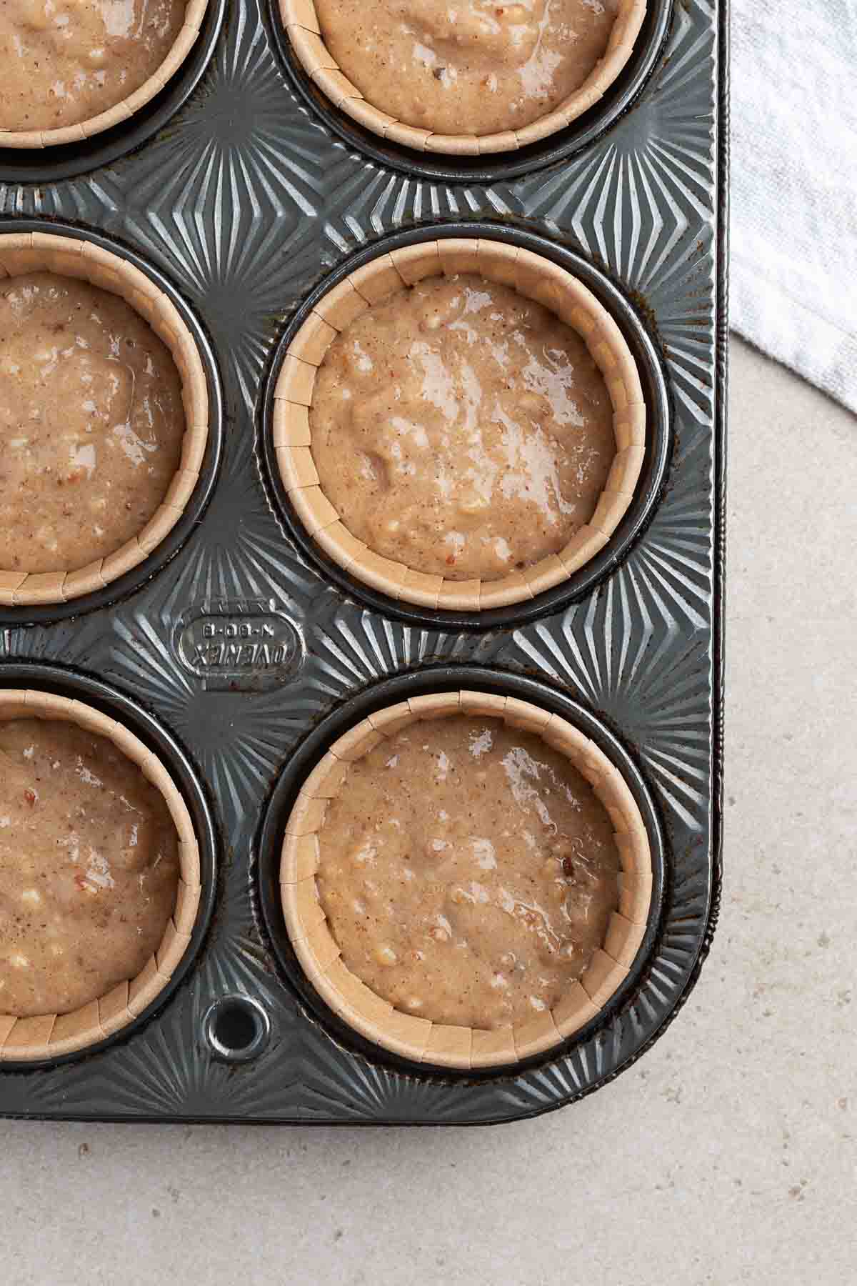 banana bread batter in lined cupcake tin