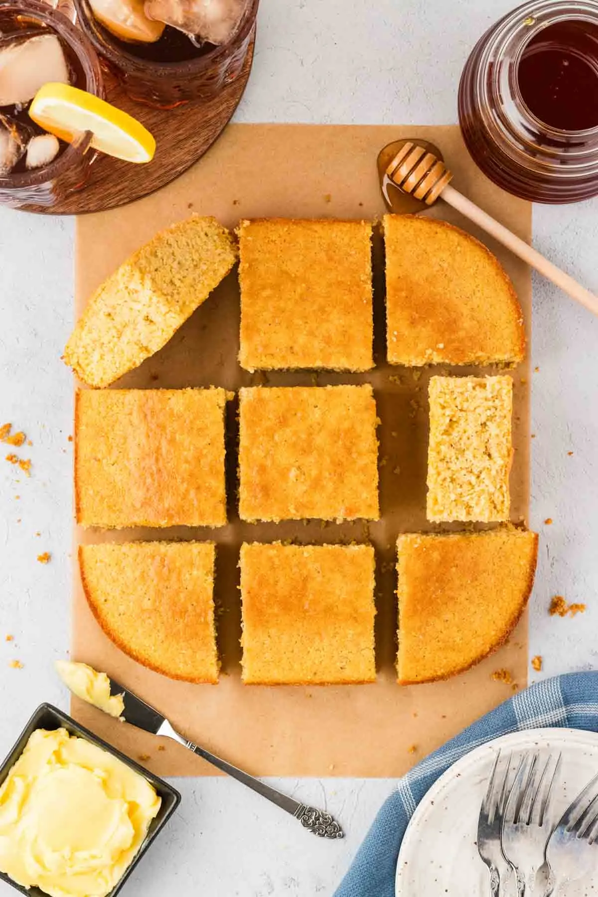 cornbread cut into 9 square pieces, with 2 flipped on their side so you can see fluffy texture