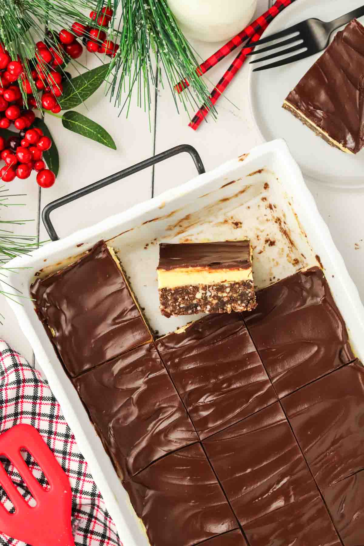 Nanaimo Bars in white casserole dish with a square cut out and place on side