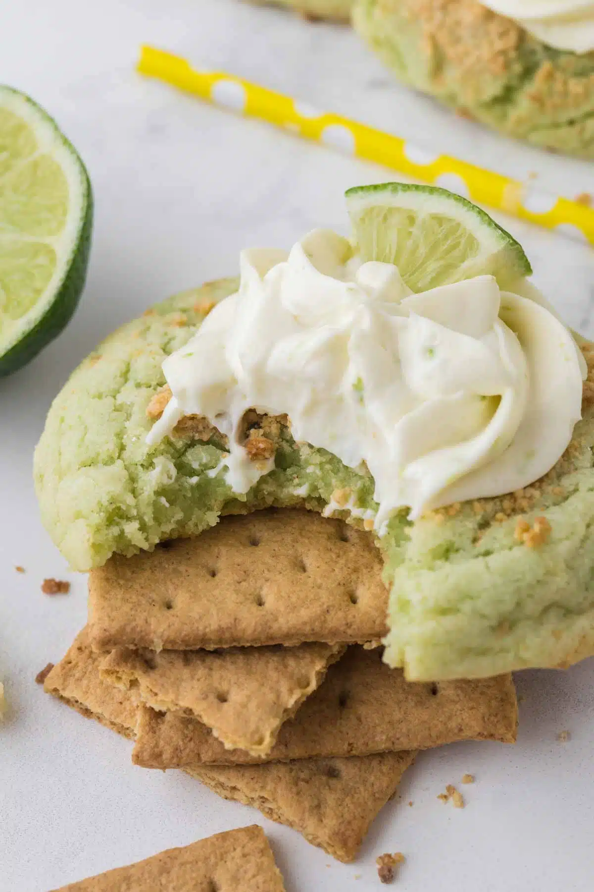 key lime pie cookie with bite taken out sitting on stack of graham crackers