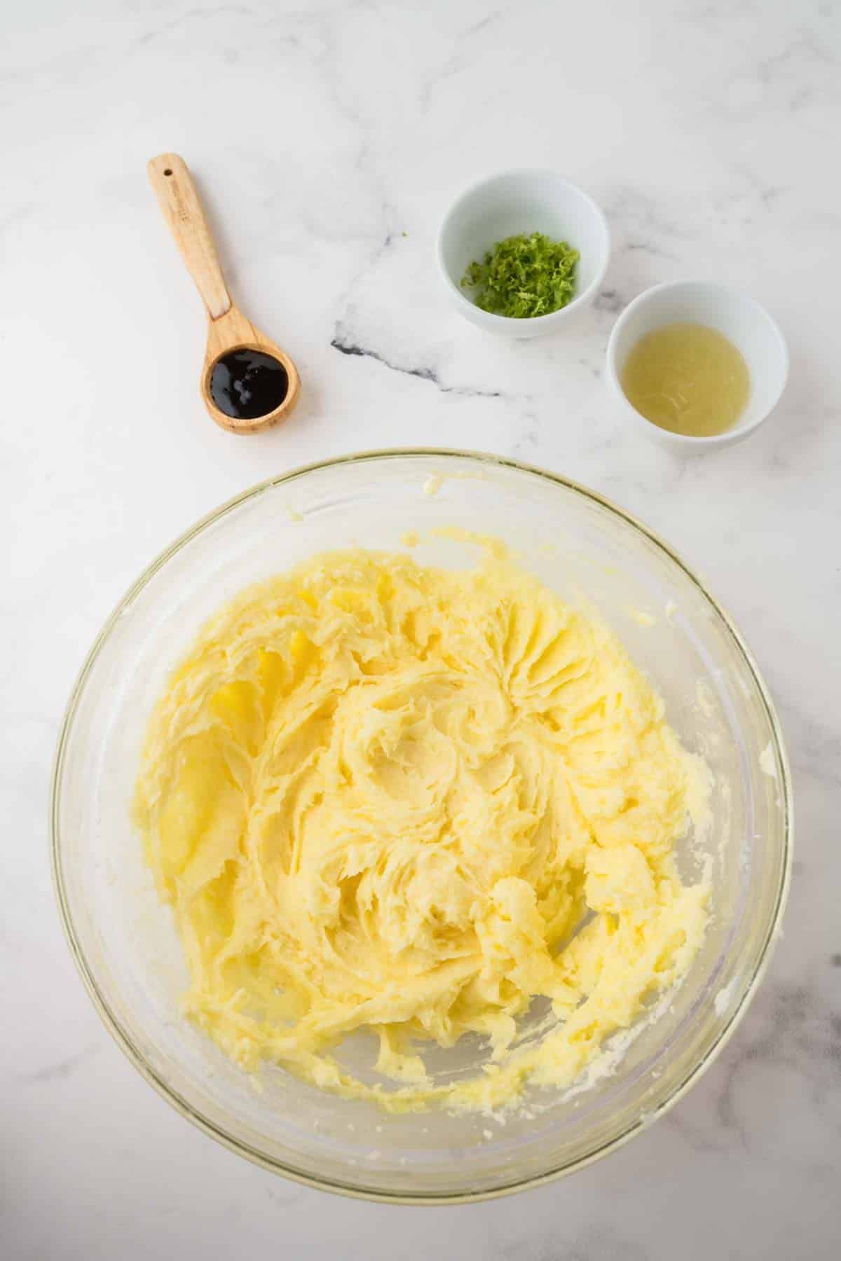 creaming wet ingredients together for key lime cookies in clear glass bowl