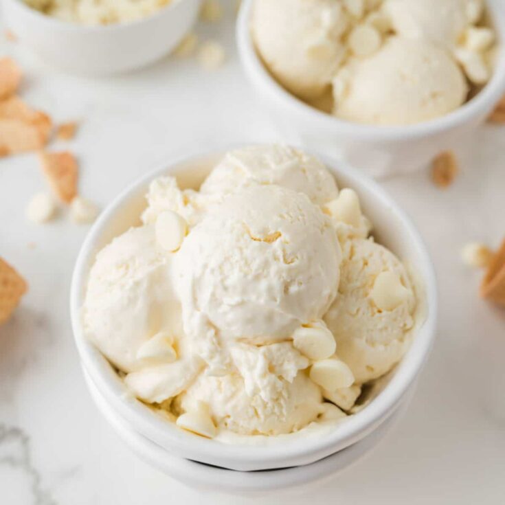 bowl of white chocolate ice cream scoops with extra white chocolate chips on top