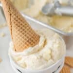 upside down white chocolate ice cream cone in a bowl