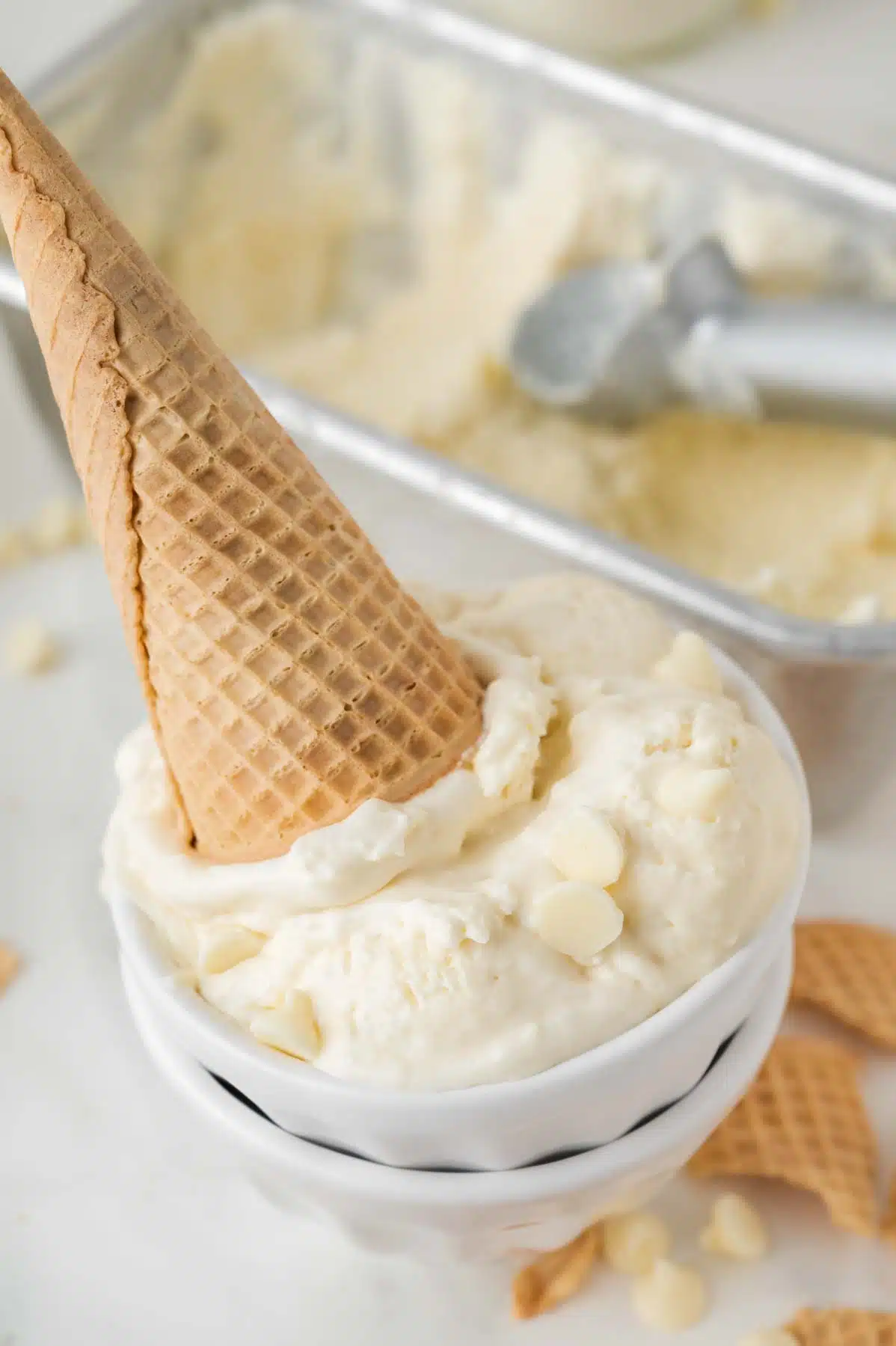 upside down white chocolate ice cream cone in a bowl