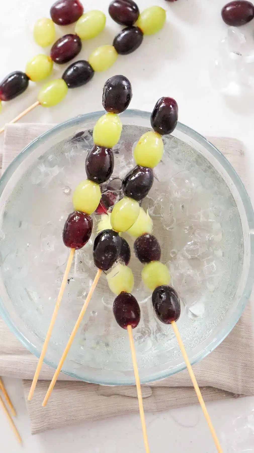 grape tanghulu skewers resting on ice bath bowl