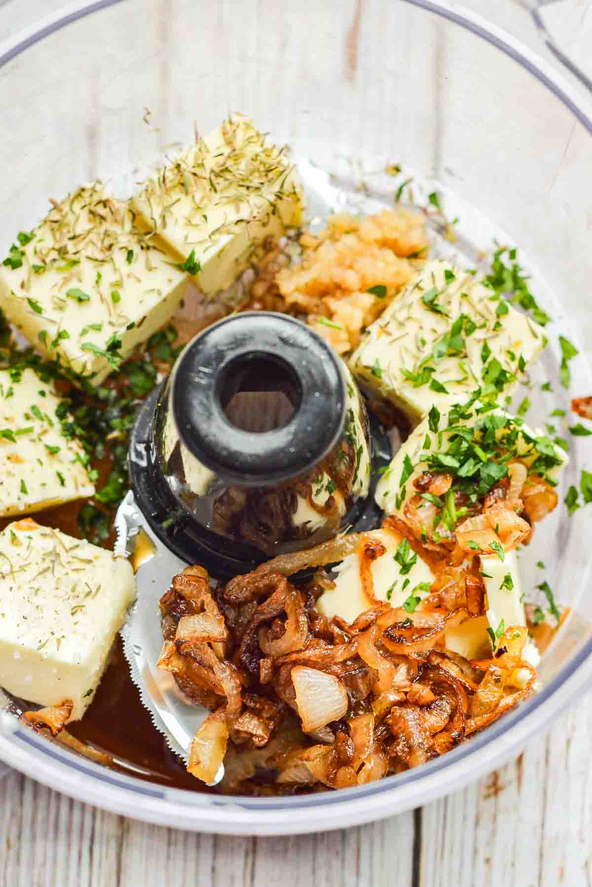 ingredients for French onion compound butter in food processor before being blended