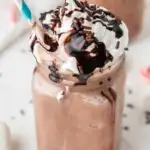 frozen hot cocoa in a mason jar with a blue and white straw