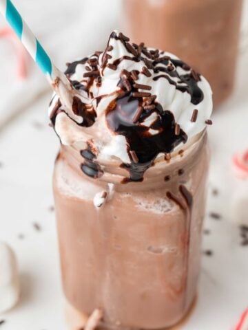 frozen hot cocoa in a mason jar with a blue and white straw