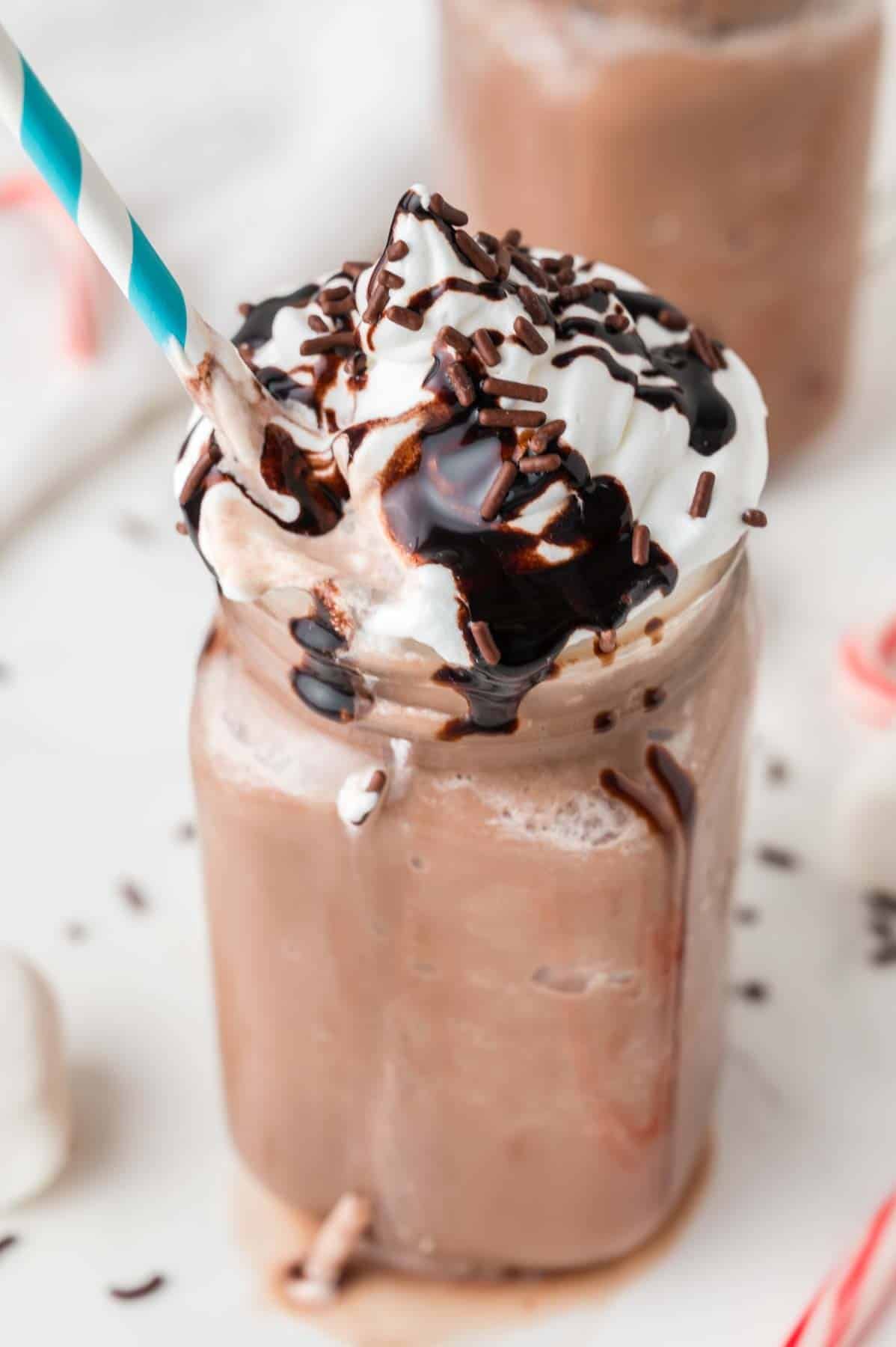 frozen hot cocoa in a mason jar with a blue and white straw