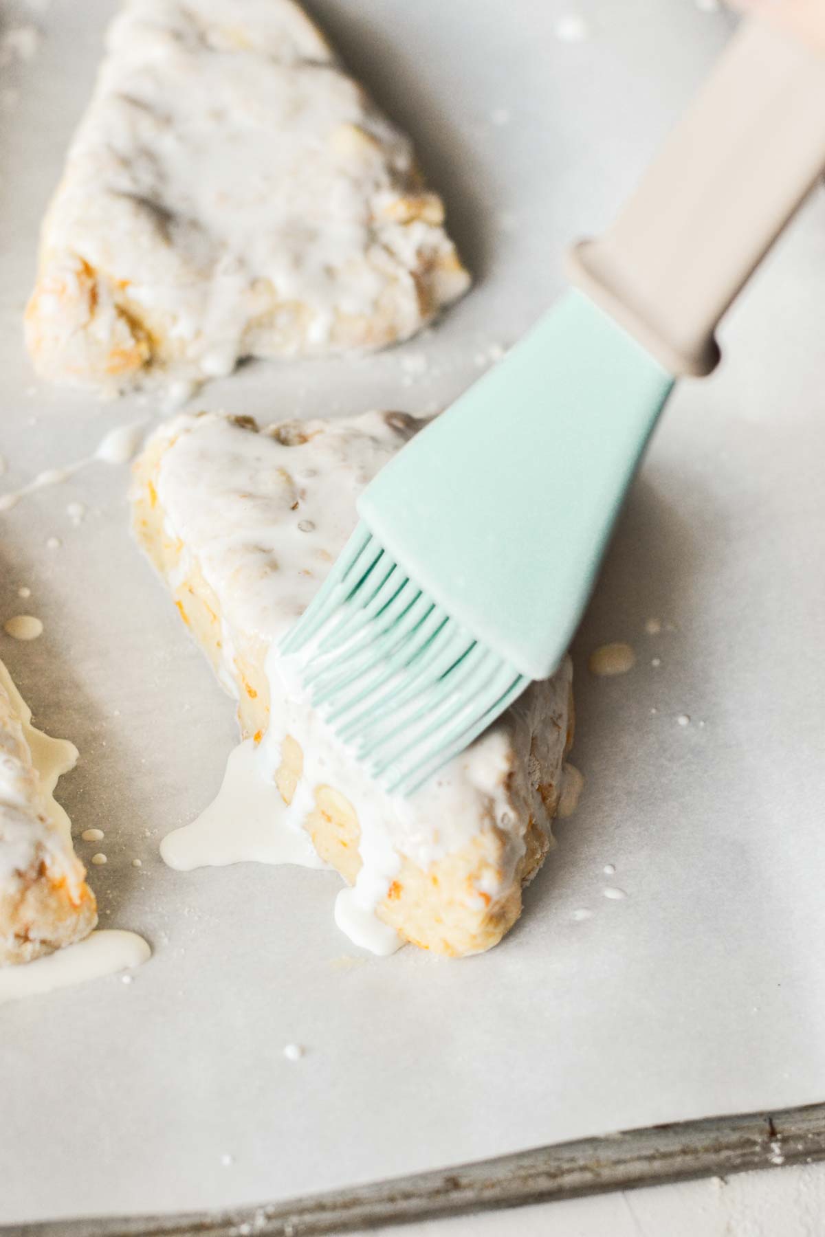 brushing on sweet glazee on top of peach scones