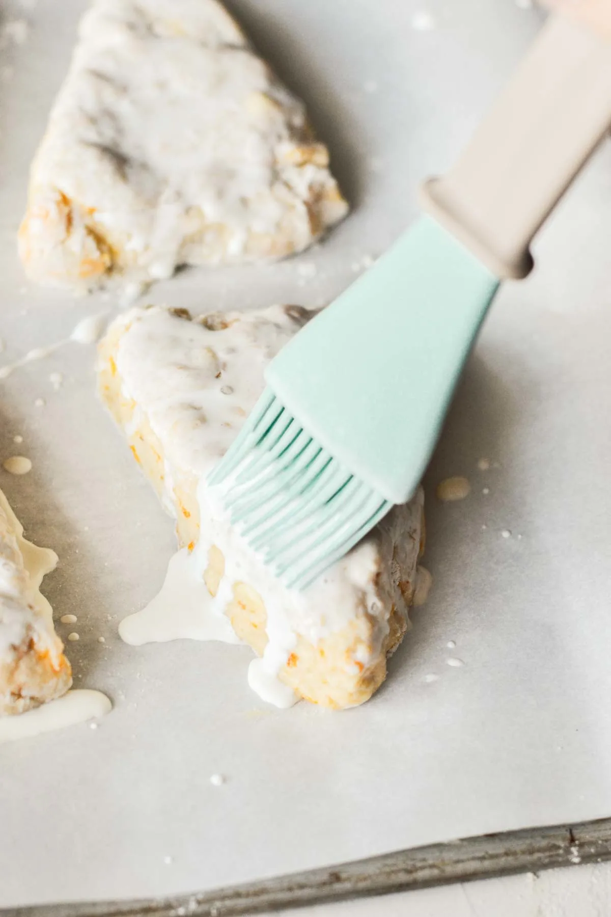 brushing on sweet glazee on top of peach scones