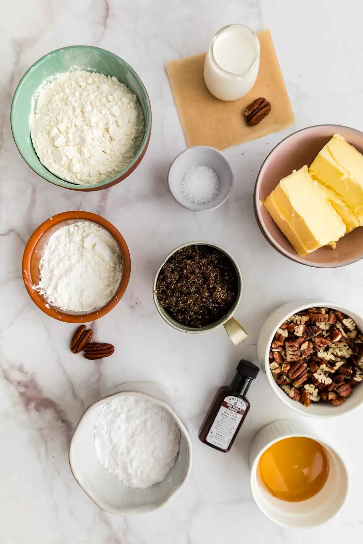 all ingredients for pecan pie bars in separate bowls, overhead shot