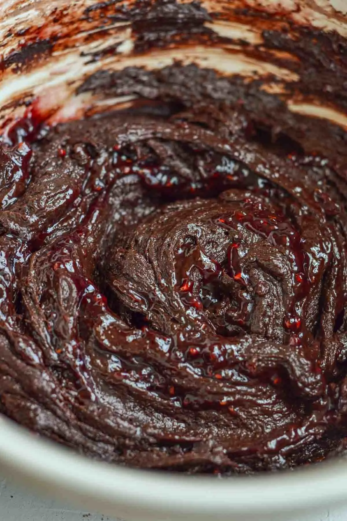 a big bowl of the chocolate cookie dough with raspberry jam swirls