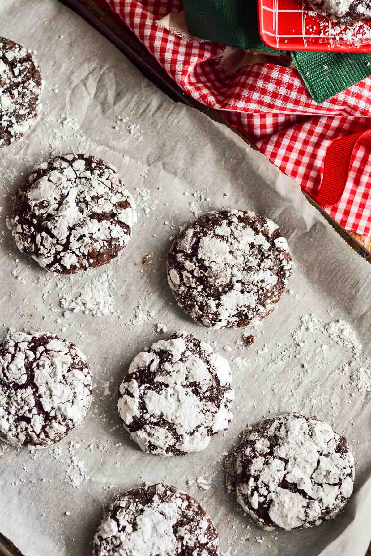 a handful of the baked chocolate crinkle cookies on parchment paper 