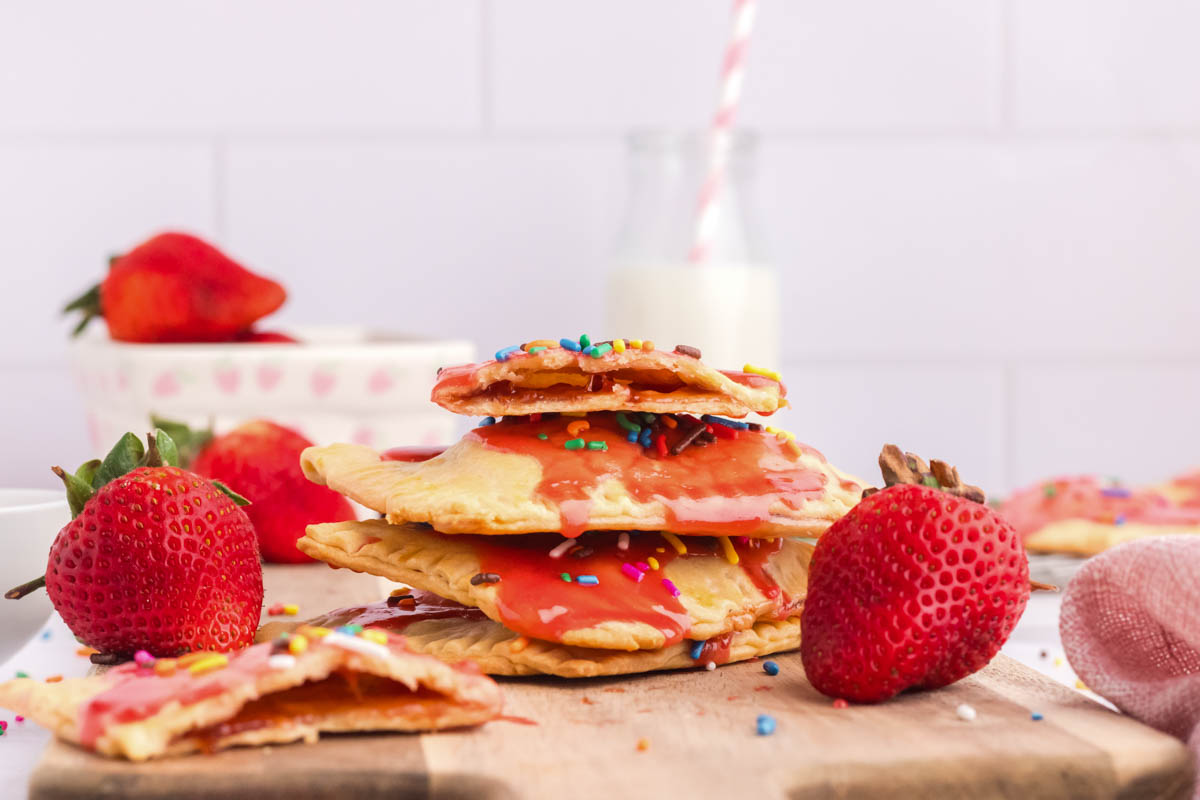 landscape picture view of stacked strawberry pop tarts with the top one broken in half so you can see filling