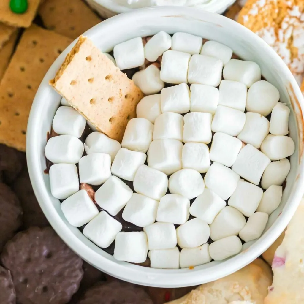 Hot Chocolate Dip in white ramekin with graham cracker dipped in