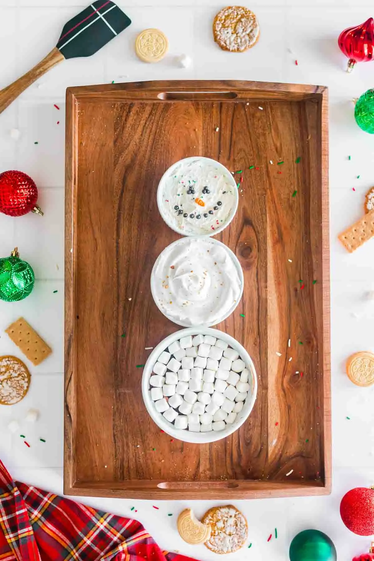 3 dessert dips stacked to look like a snowman on a wooden tray