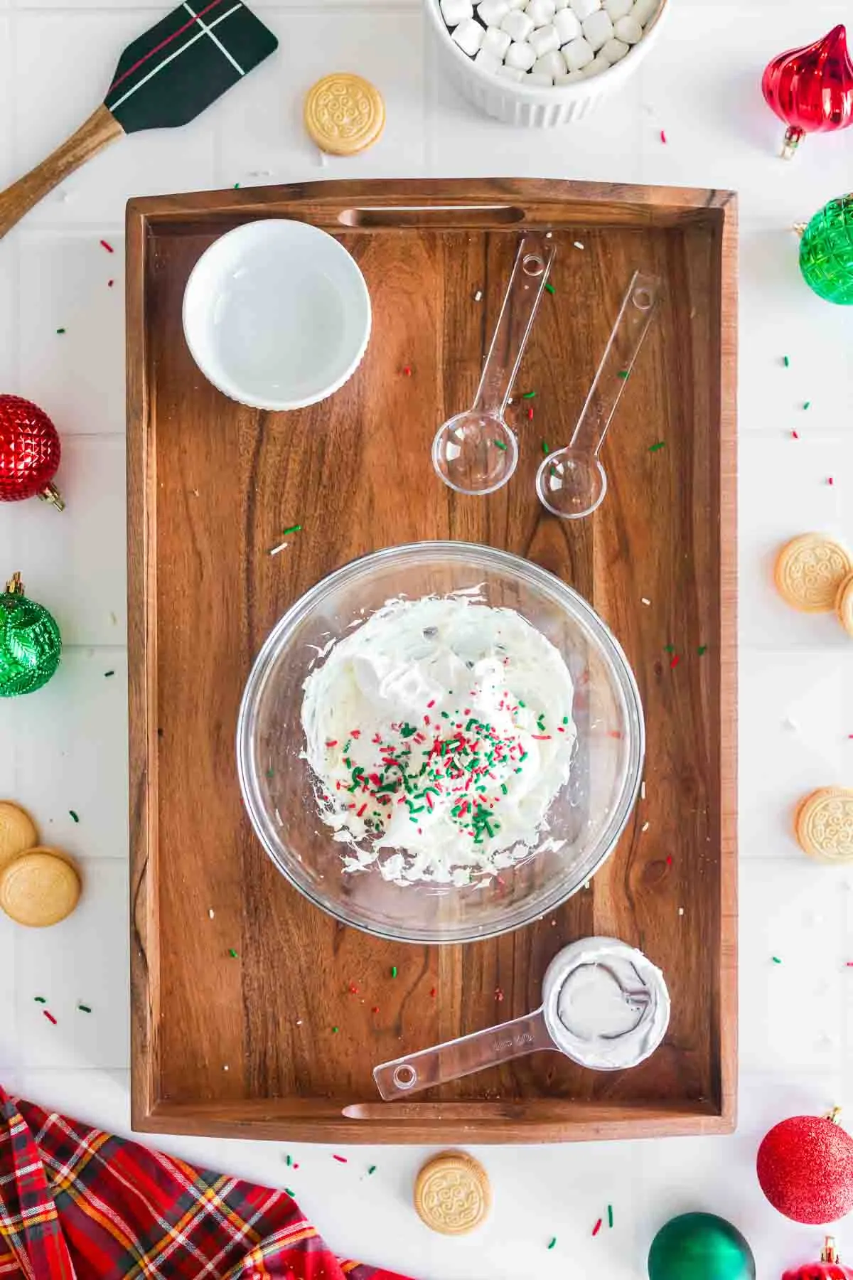 christmas colored sprinkles on top of the whipped sugar cookie dip in glass bowl