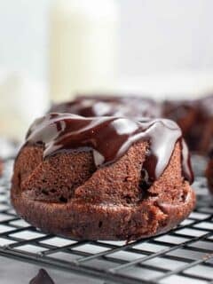 portrait photo of a side angle view of mini chocolate bundt cake with chocolate ganache.