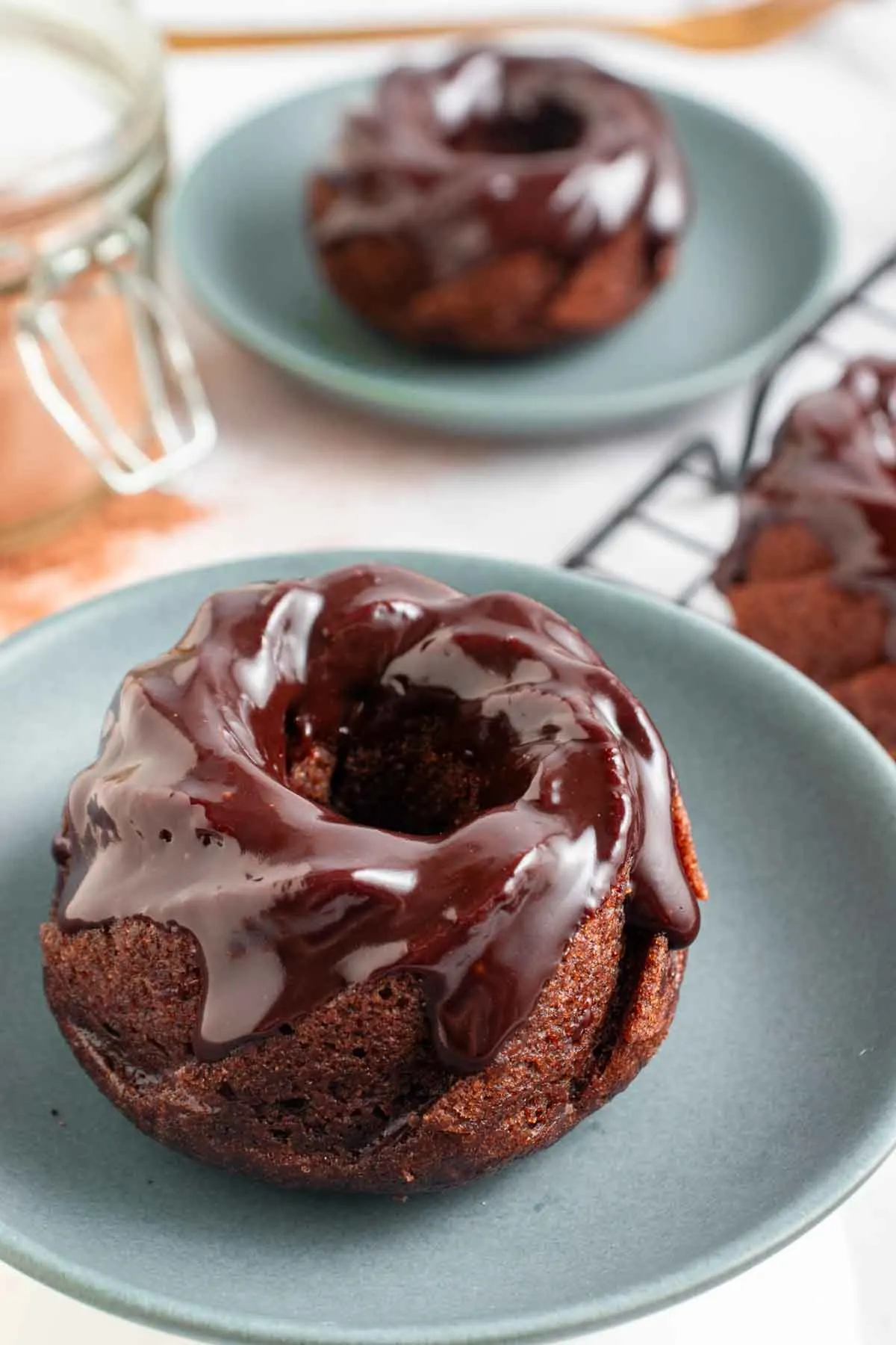 2 mini chocolate bundt cakes on light blue plates.