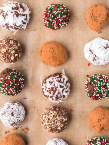 Chocolate Rum Balls with different toppings on parchment paper.