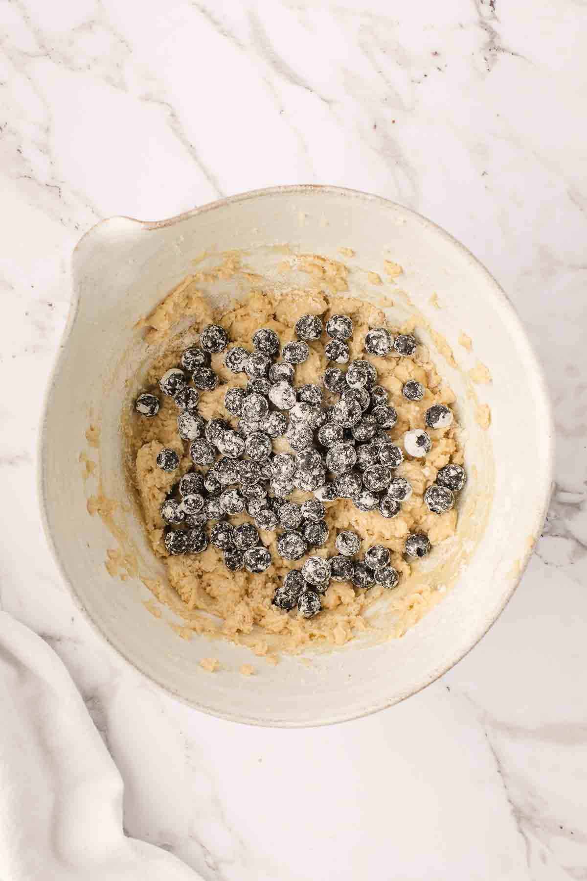 mixing bowl with floured blueberries before mixing into coffee cake batter.