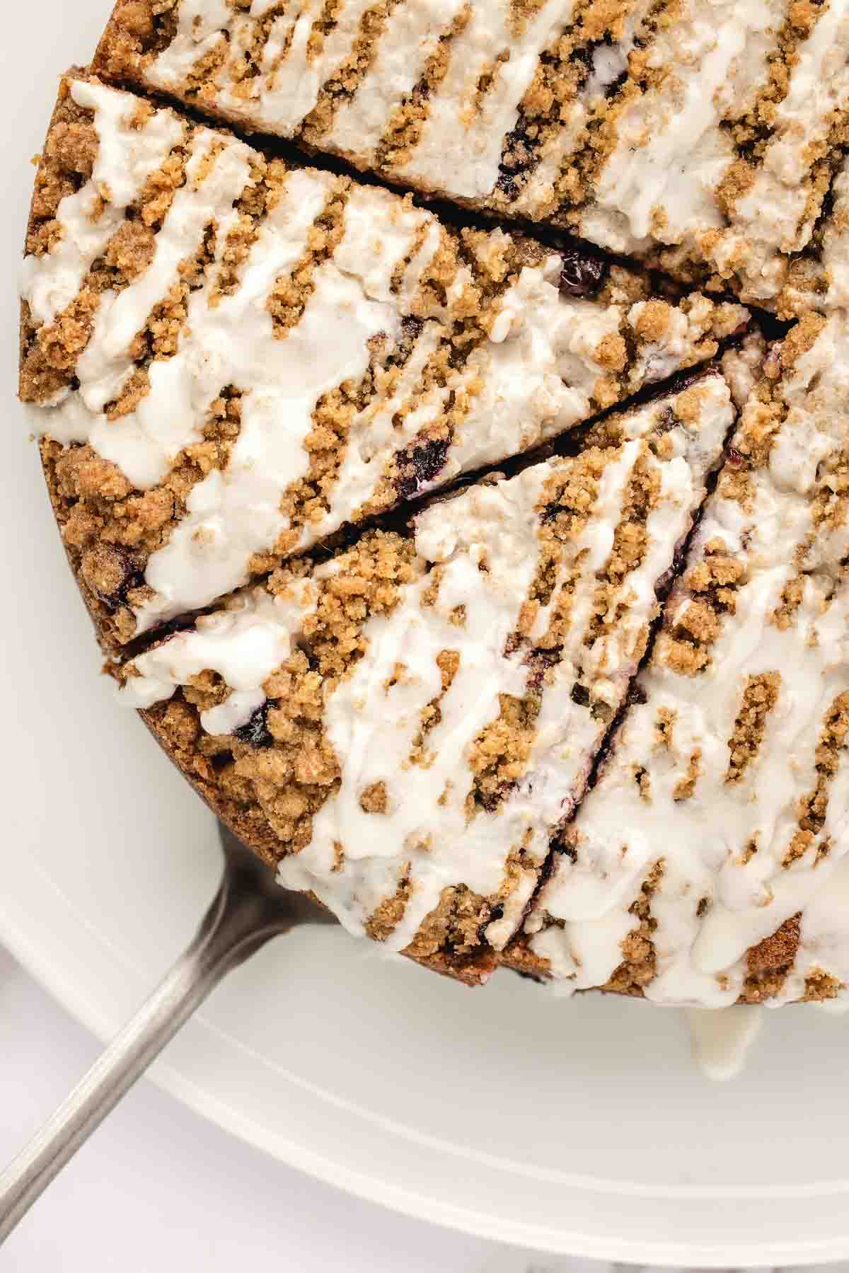 overhead view of icing covered, sliced blueberry coffee cake.